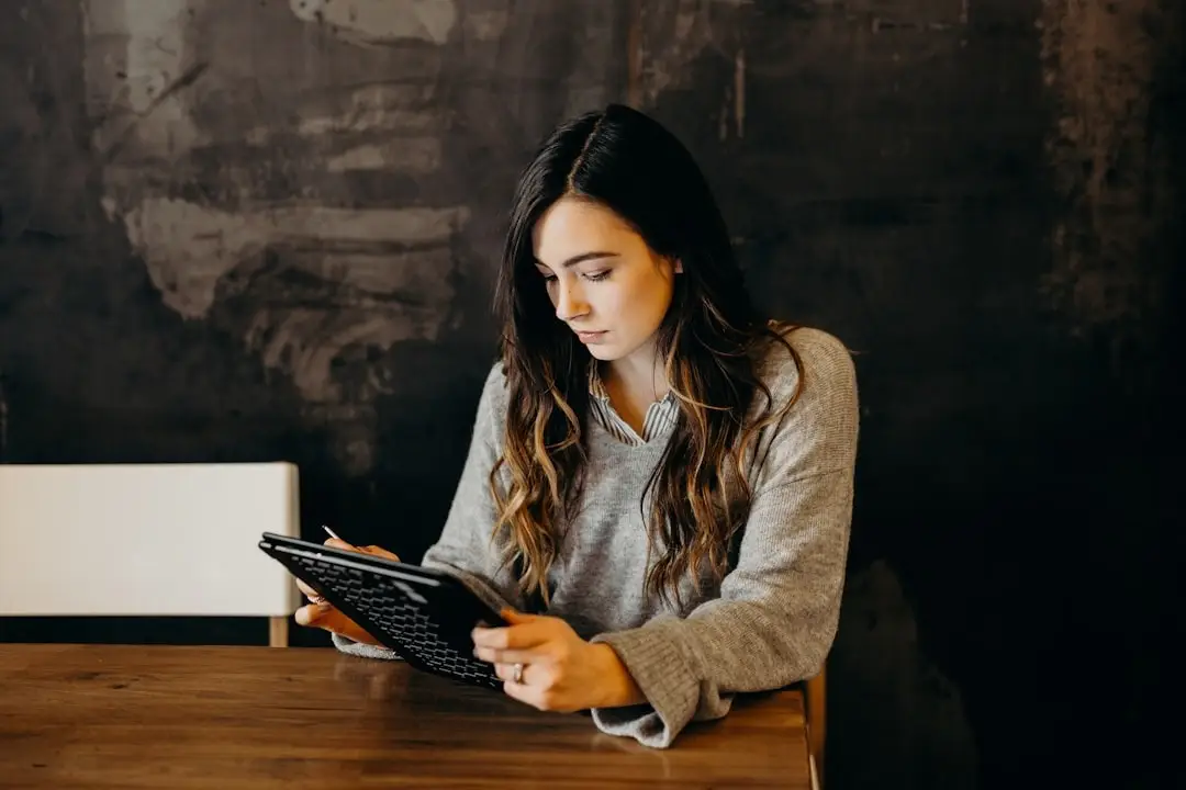 A young woman looking at her tablet, having an online English class